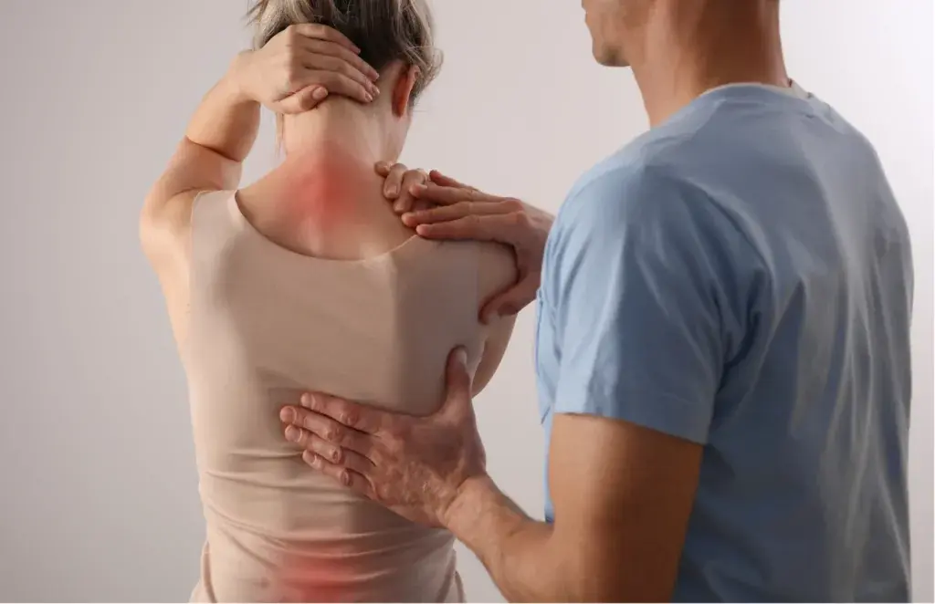 Osteopata che valuta le zone di dolore su schiena e cervicale